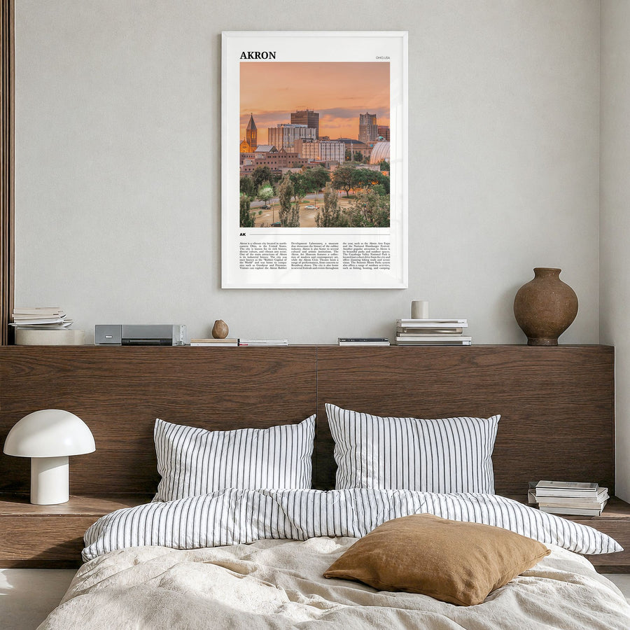 Akron Travel Poster in a white wood frame, hanging in a bedroom