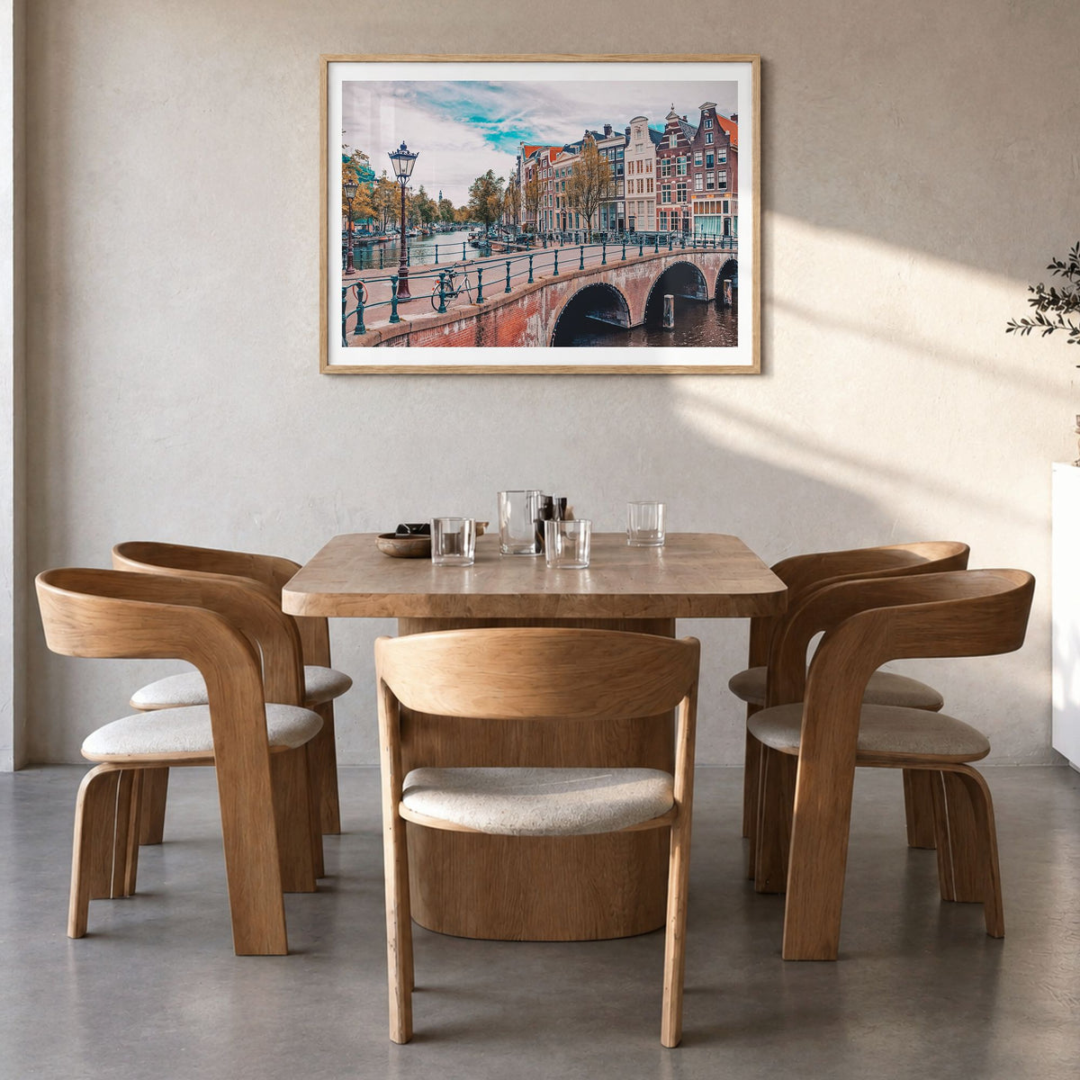 Amsterdam Photo Poster in a natural wood frame, hanging in a dining room, white border