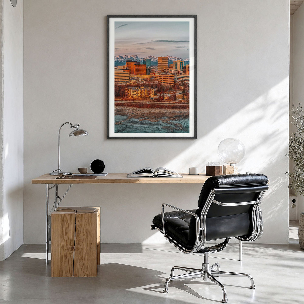 Anchorage Photo Poster in a black wood frame, hanging in a bright home office, white border