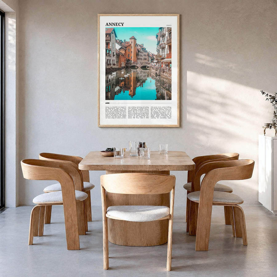 Annecy Travel Poster in a natural wood frame, hanging in a dining room