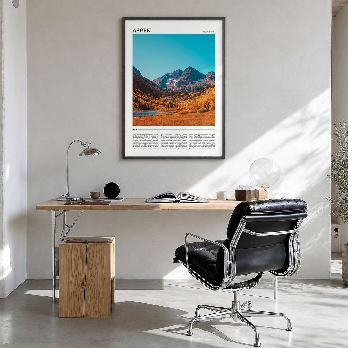 Aspen Travel Poster in a black wood frame, hanging in a bright home office