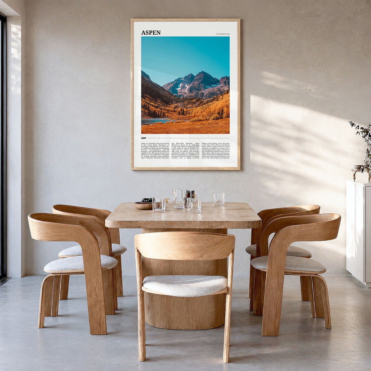 Aspen Travel Poster in a natural wood frame, hanging in a dining room