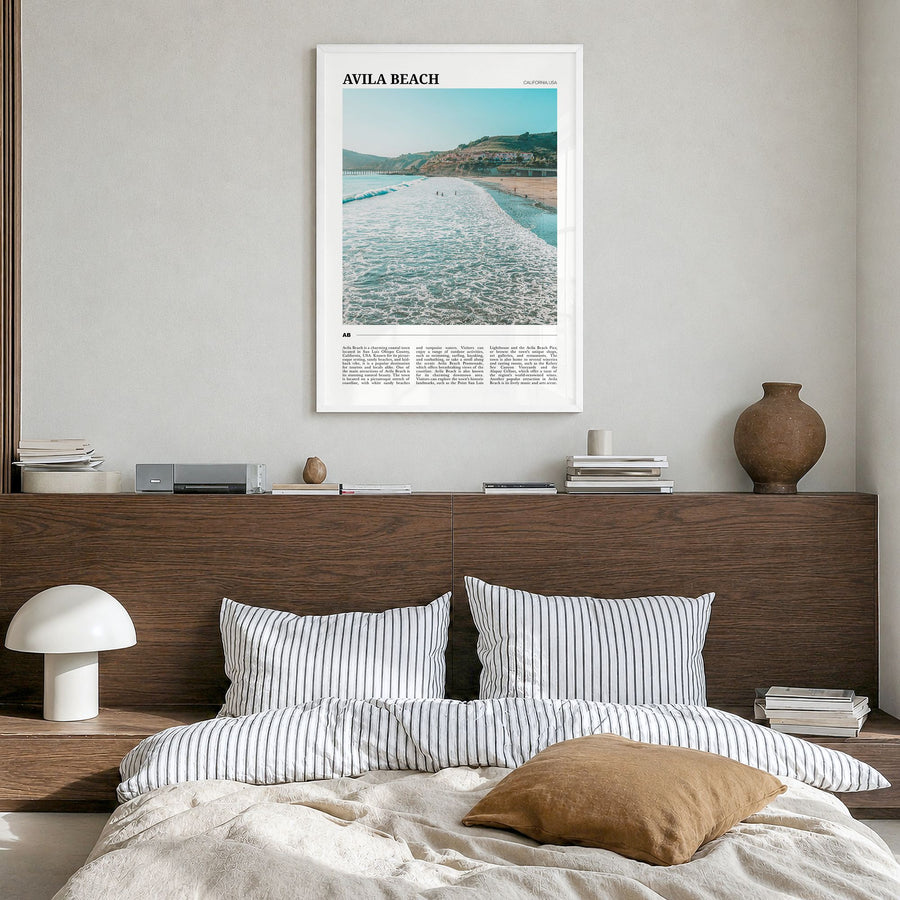 Avila Beach Travel Poster in a white wood frame, hanging in a bedroom