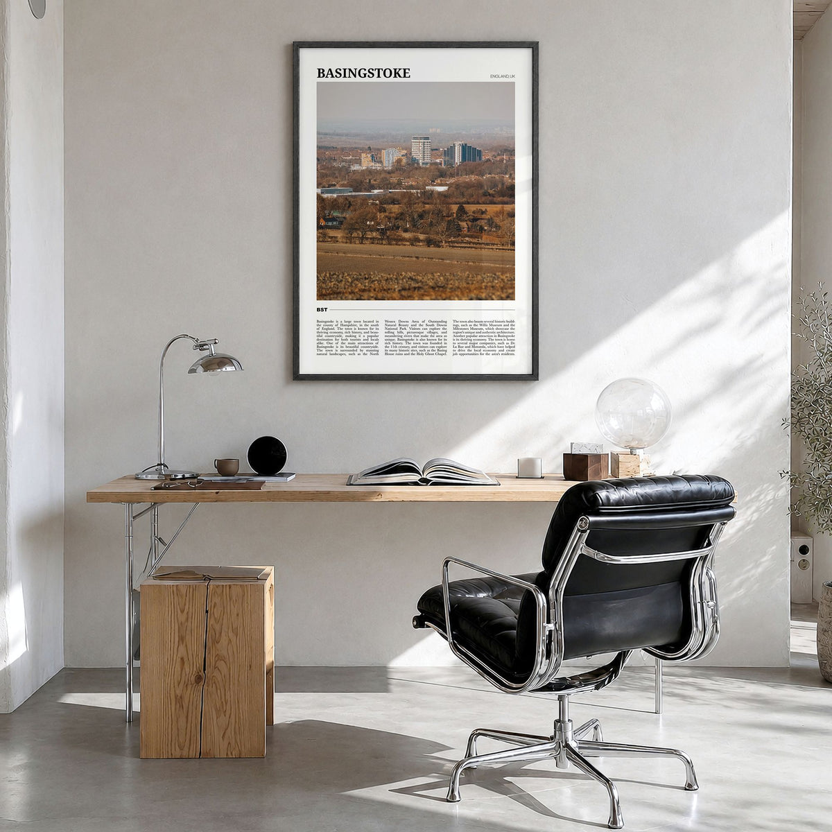 Basingstoke Travel Poster in a black wood frame, hanging in a bright home office