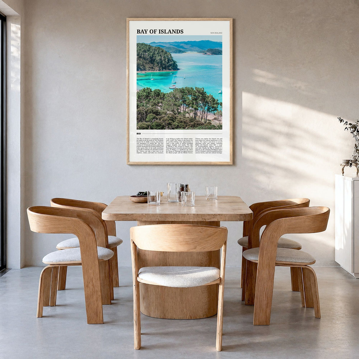 Bay of Islands Travel Poster in a natural wood frame, hanging in a dining room