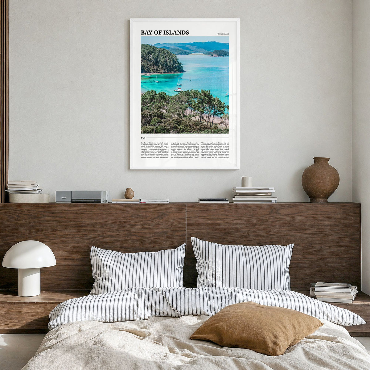 Bay of Islands Travel Poster in a white wood frame, hanging in a bedroom