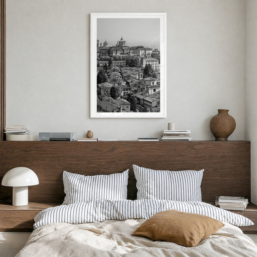 Bergamo Photo Poster in a white wood frame, hanging in a bedroom, white border