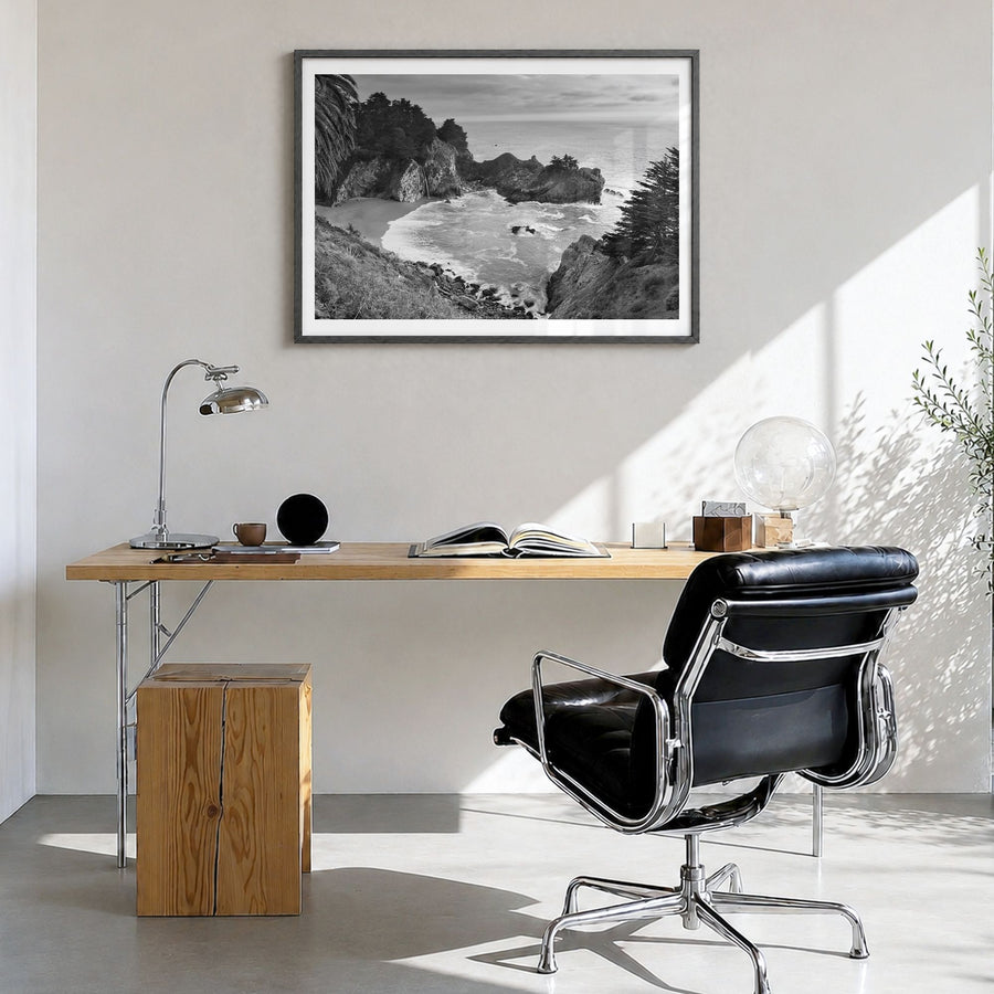 Big Sur Photo Poster in a black wood frame, hanging in a bright home office, white border