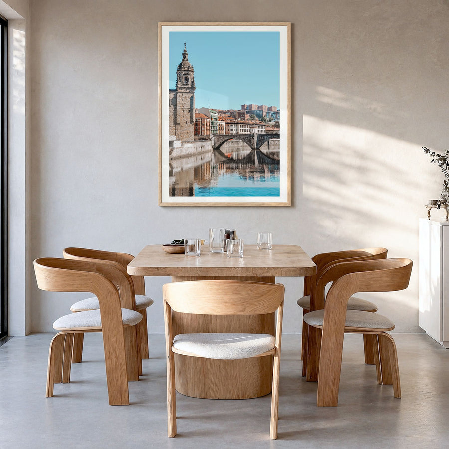 Bilbao Photo Poster in a natural wood frame, hanging in a dining room, white border