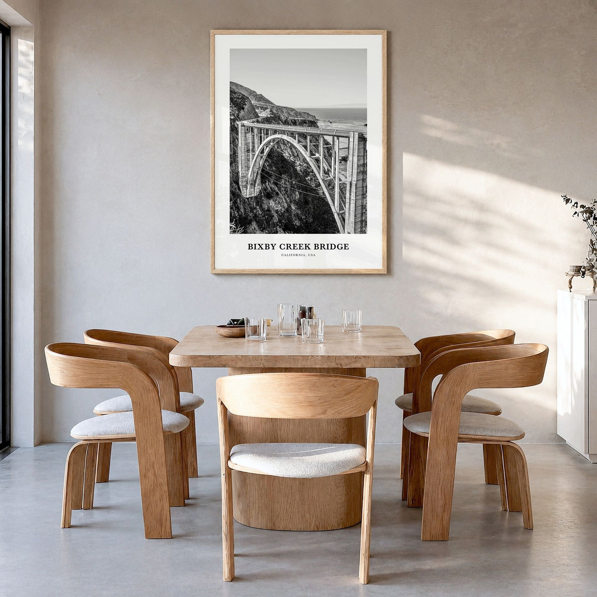 Bixby Creek Bridge Classic Poster in a natural wood frame, hanging in a dining room