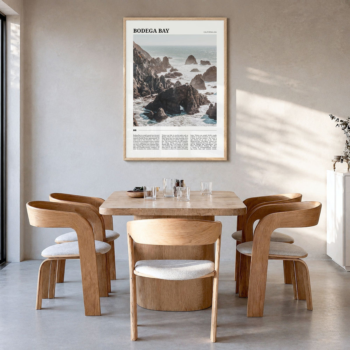 Bodega Bay Travel Poster in a natural wood frame, hanging in a dining room