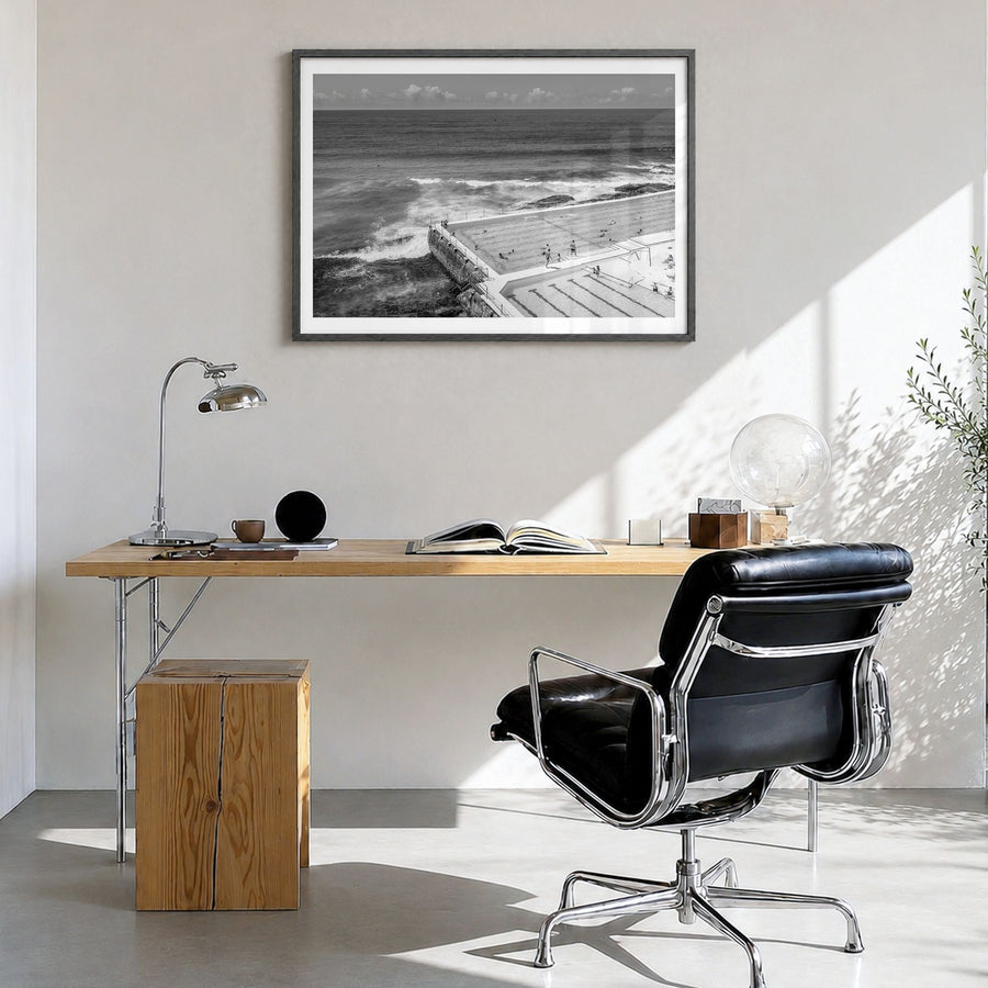 Bondi Beach Photo Poster in a black wood frame, hanging in a bright home office, white border