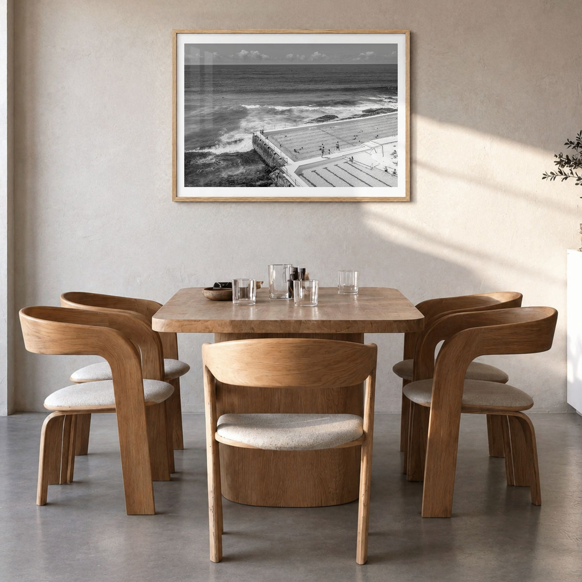 Bondi Beach Photo Poster in a natural wood frame, hanging in a dining room, white border