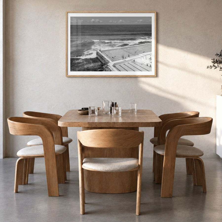 Bondi Beach Photo Poster in a natural wood frame, hanging in a dining room, white border
