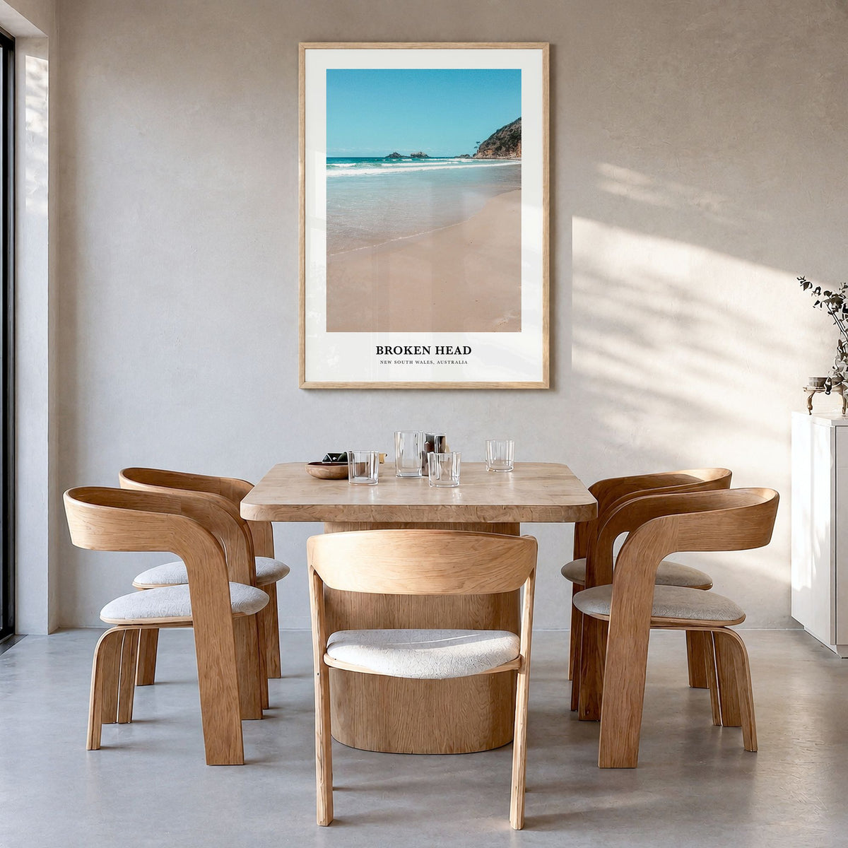 Broken Head Classic Poster in a natural wood frame, hanging in a dining room