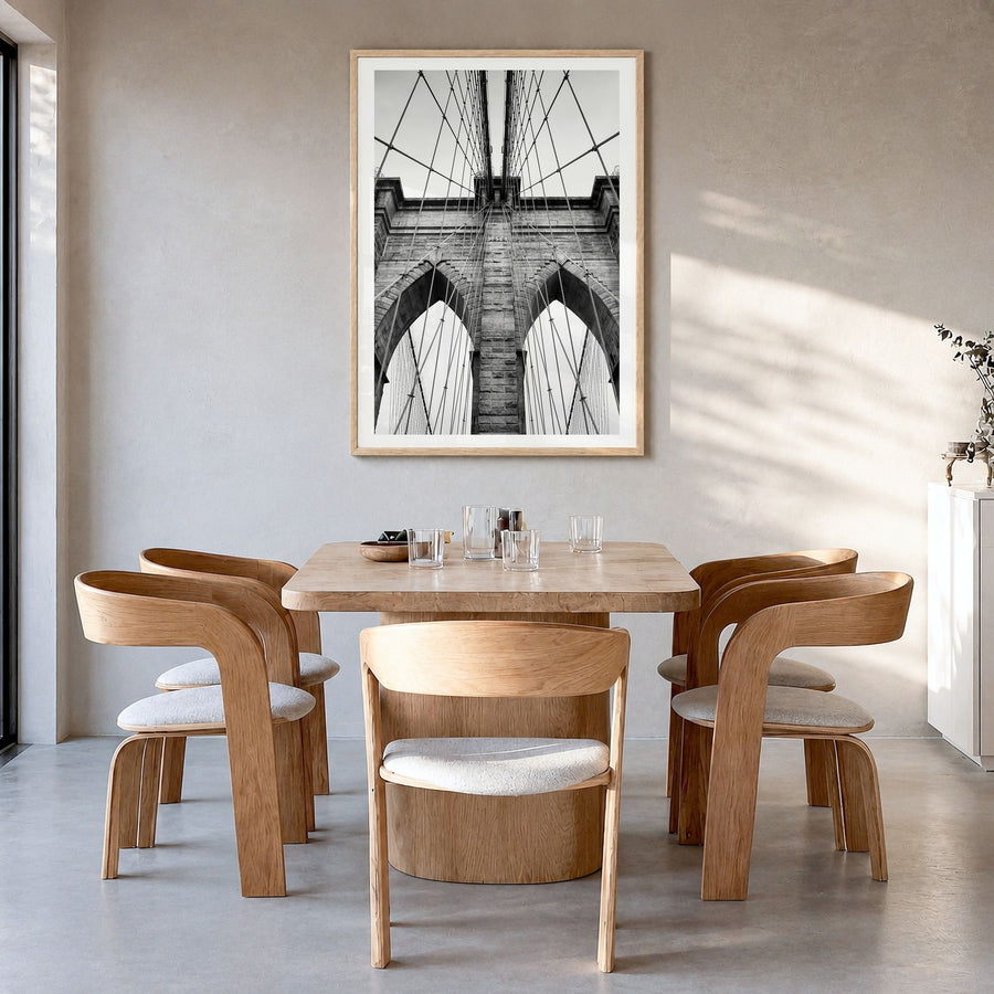 Brooklyn Bridge Photo Poster in a natural wood frame, hanging in a dining room, white border