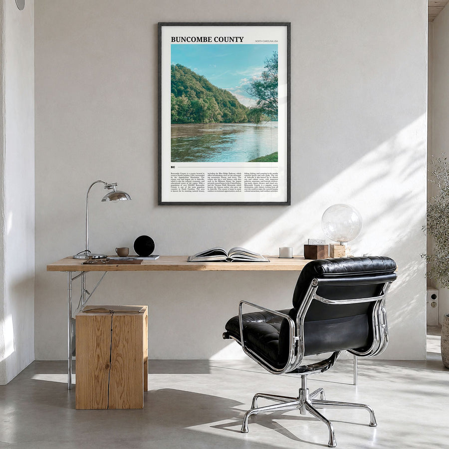 Buncombe County Travel Poster in a black wood frame, hanging in a bright home office