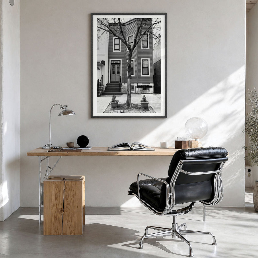 Bushwick Photo Poster in a black wood frame, hanging in a bright home office, white border