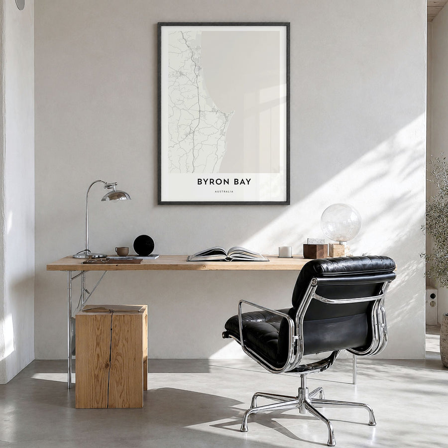 Byron Bay Map Poster in a black wood frame, hanging in a bright home office