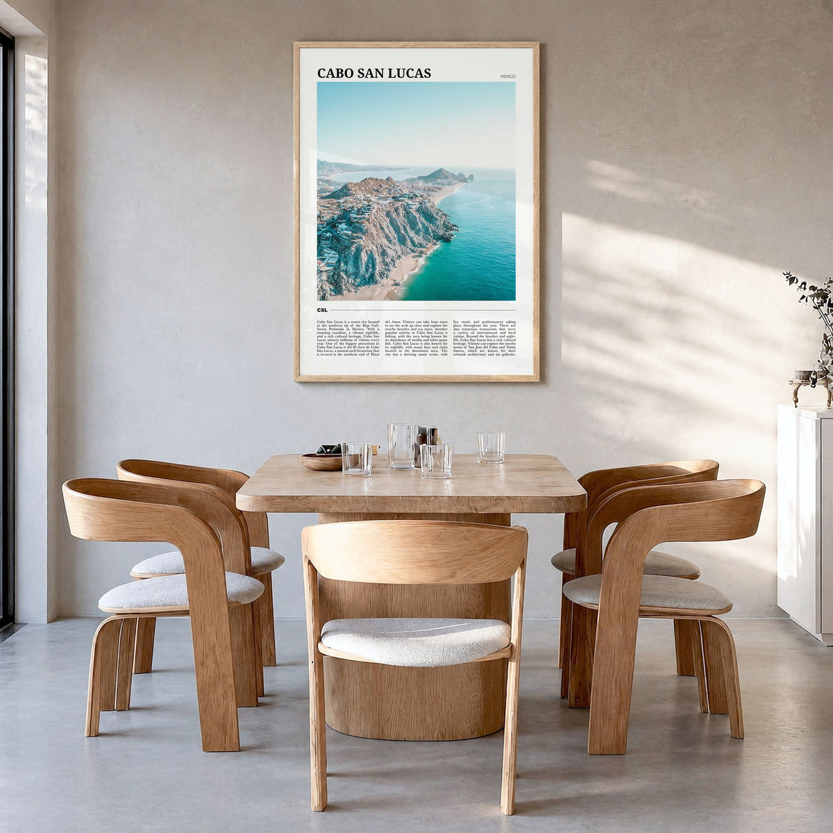 Cabo San Lucas Travel Poster in a natural wood frame, hanging in a dining room