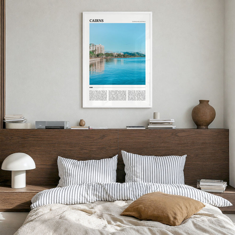 Cairns Travel Poster in a white wood frame, hanging in a bedroom
