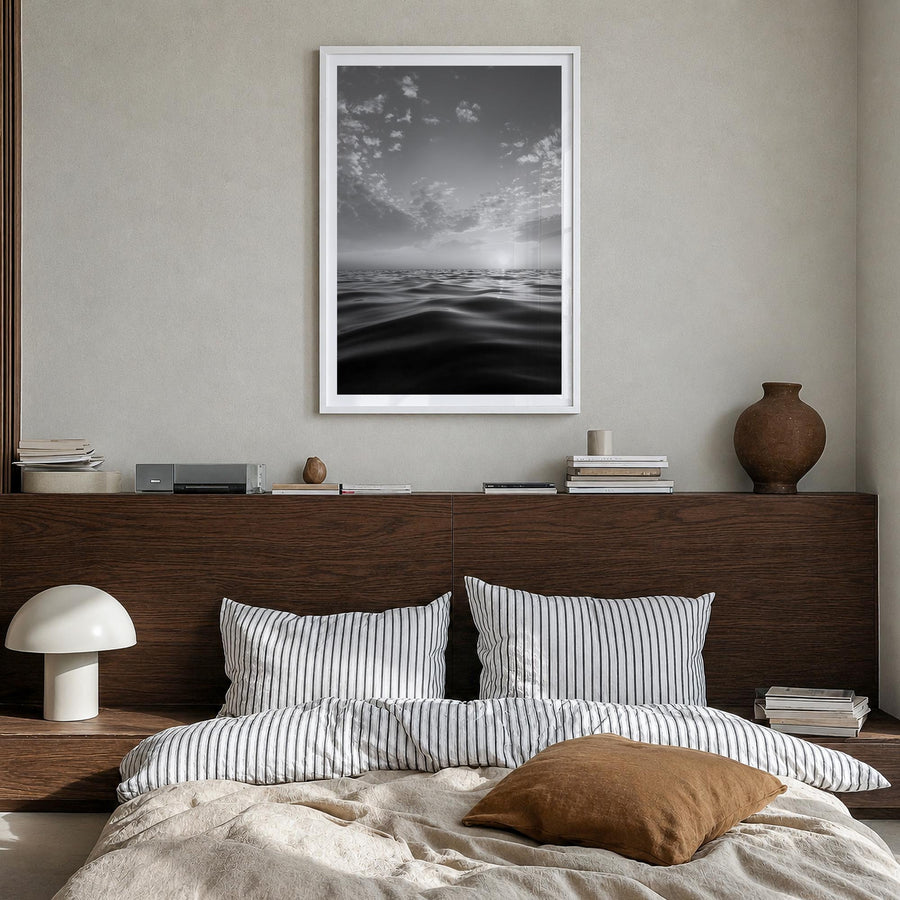 Calm Sunset black & white photo poster – vertical wall art in white wood frame with white border, hanging on wall