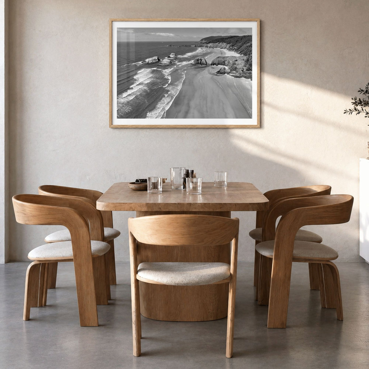 Cannon Beach Photo Poster in a natural wood frame, hanging in a dining room, white border