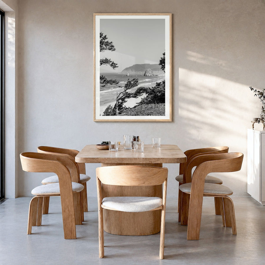 Cannon Beach Photo Poster in a natural wood frame, hanging in a dining room, white border