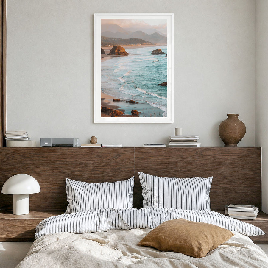 Cannon Beach Photo Poster in a white wood frame, hanging in a bedroom, white border