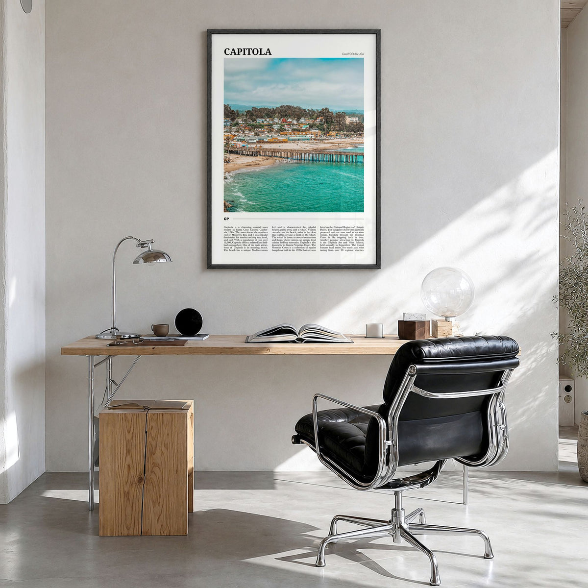 Capitola Travel Poster in a black wood frame, hanging in a bright home office