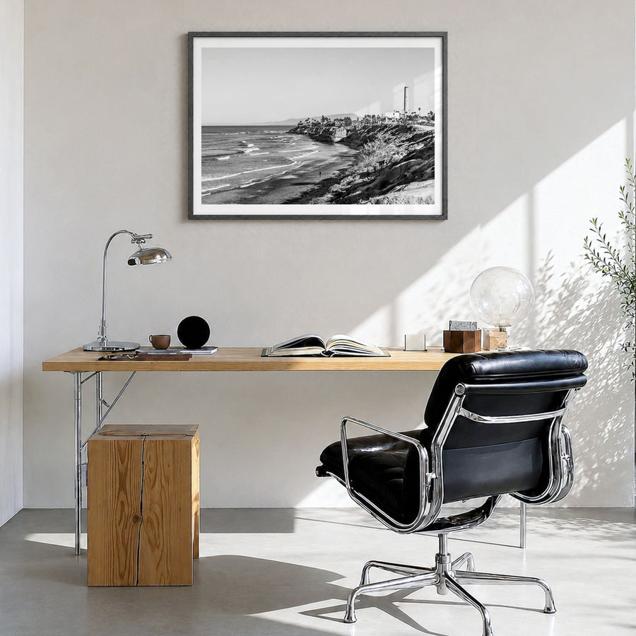 Carlsbad Photo Poster in a black wood frame, hanging in a bright home office, white border