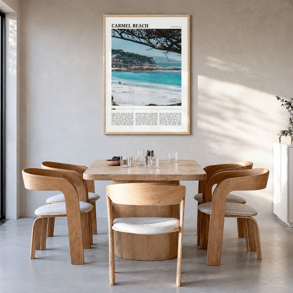 Carmel Beach Travel Poster in a natural wood frame, hanging in a dining room