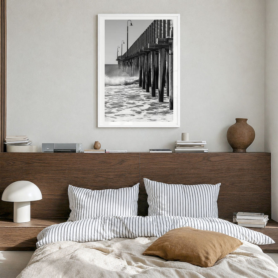 Cayucos Photo Poster in a white wood frame, hanging in a bedroom, white border