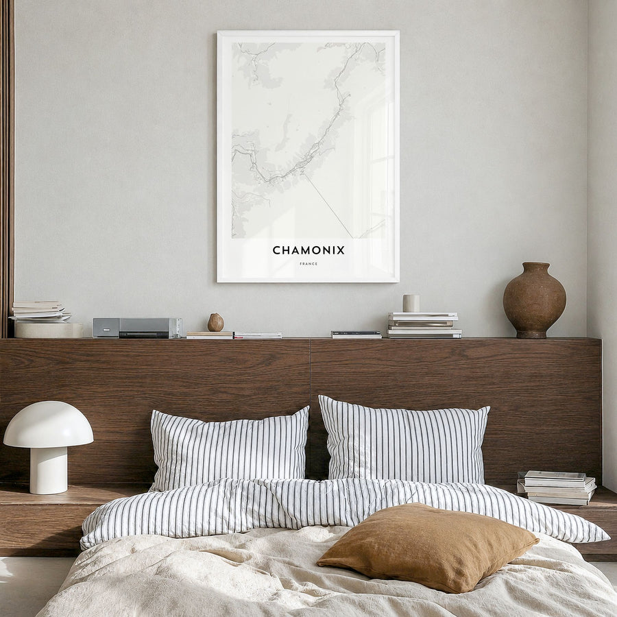 Chamonix Map Poster in a white wood frame, hanging in a bedroom