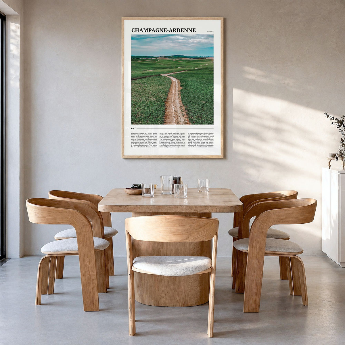 Champagne-Ardenne Travel Poster in a natural wood frame, hanging in a dining room