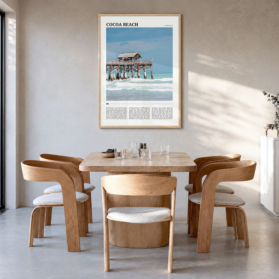 Cocoa Beach Travel Poster in a natural wood frame, hanging in a dining room