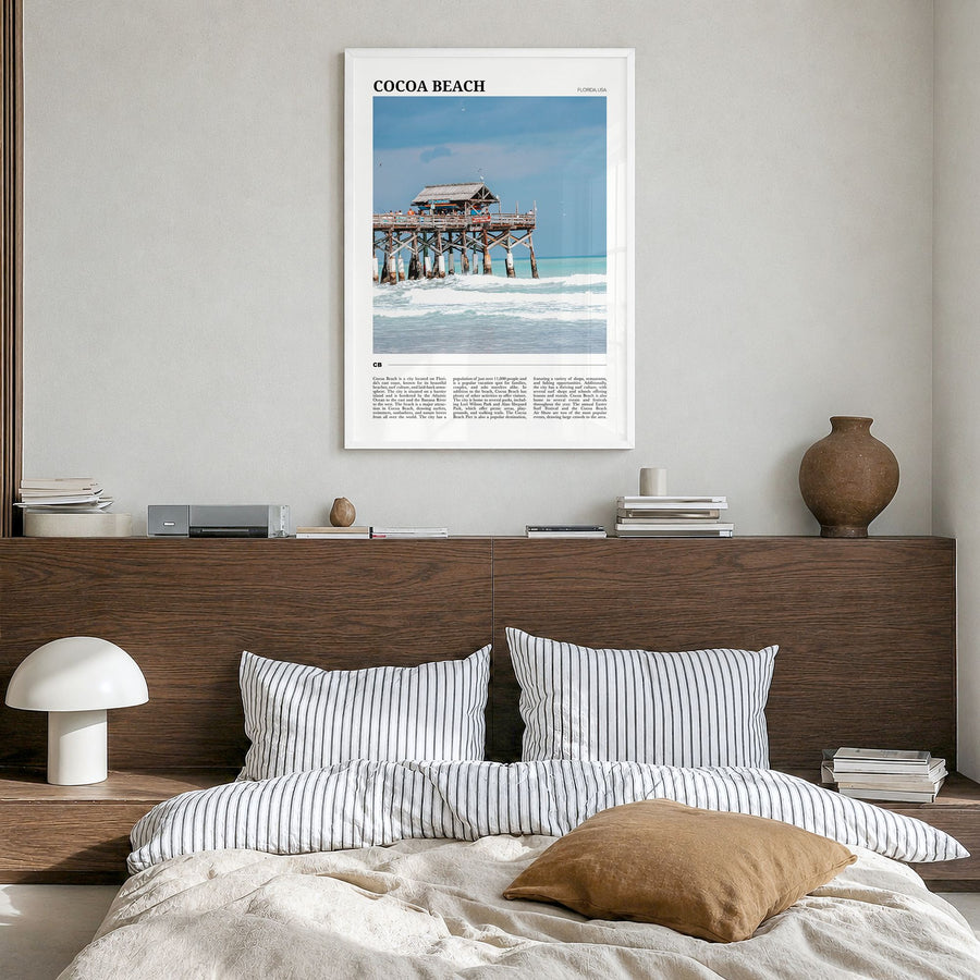 Cocoa Beach Travel Poster in a white wood frame, hanging in a bedroom