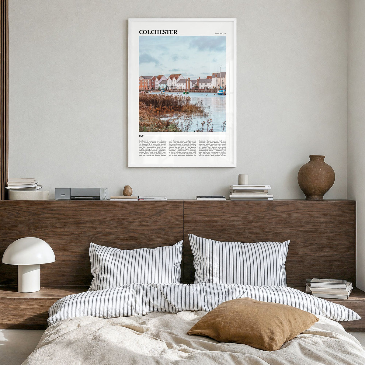 Colchester Travel Poster in a white wood frame, hanging in a bedroom