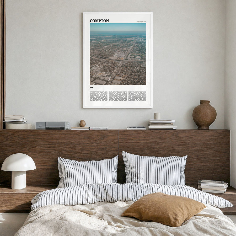 Compton Travel Poster in a white wood frame, hanging in a bedroom