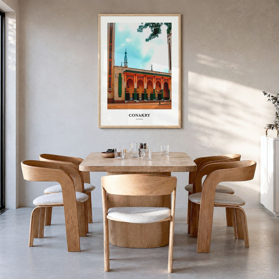 Conakry Classic Poster in a natural wood frame, hanging in a dining room