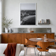 Coogee Beach black & white photo poster of Sydney, New South Wales – vertical wall art in white wood frame, hanging on wall