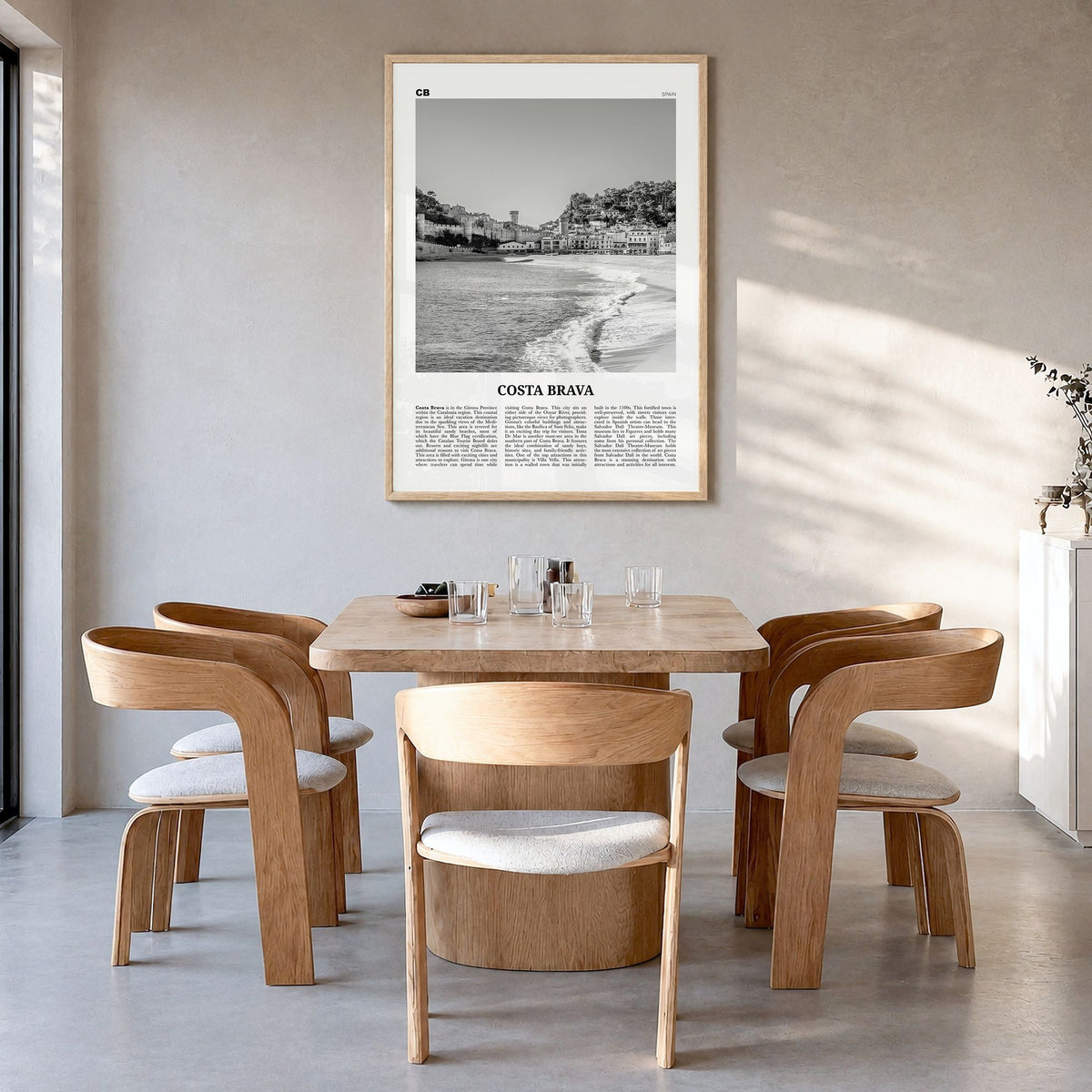 Costa Brava Newspaper Poster in a natural wood frame, hanging in a dining room