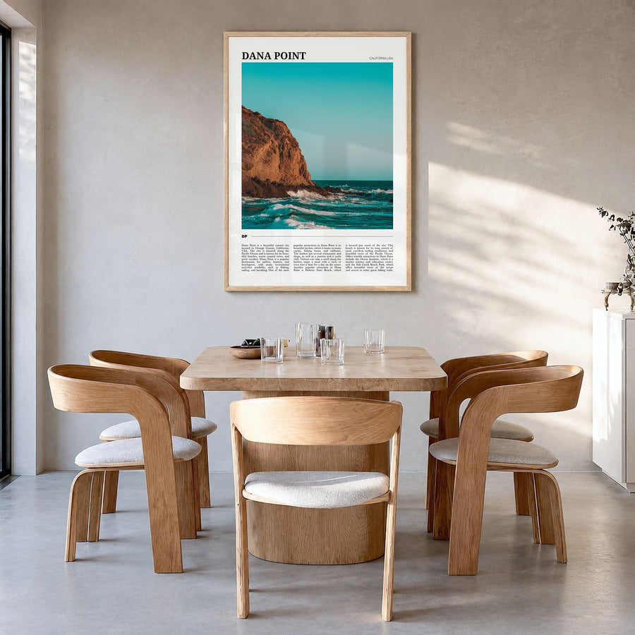 Dana Point Travel Poster in a natural wood frame, hanging in a dining room