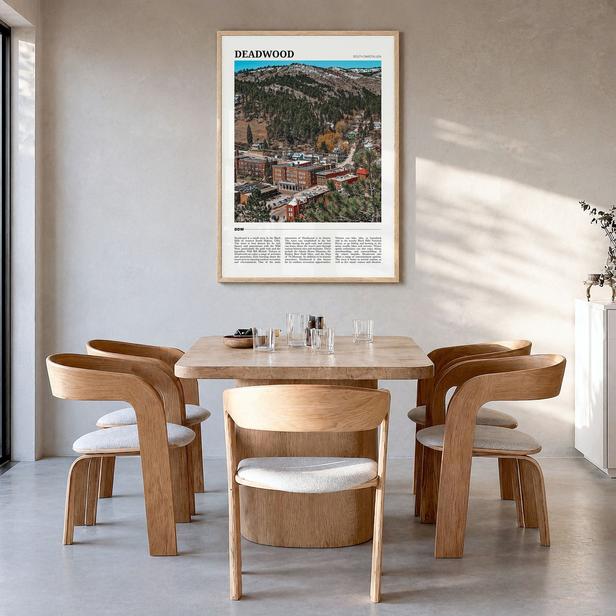 Deadwood Travel Poster in a natural wood frame, hanging in a dining room