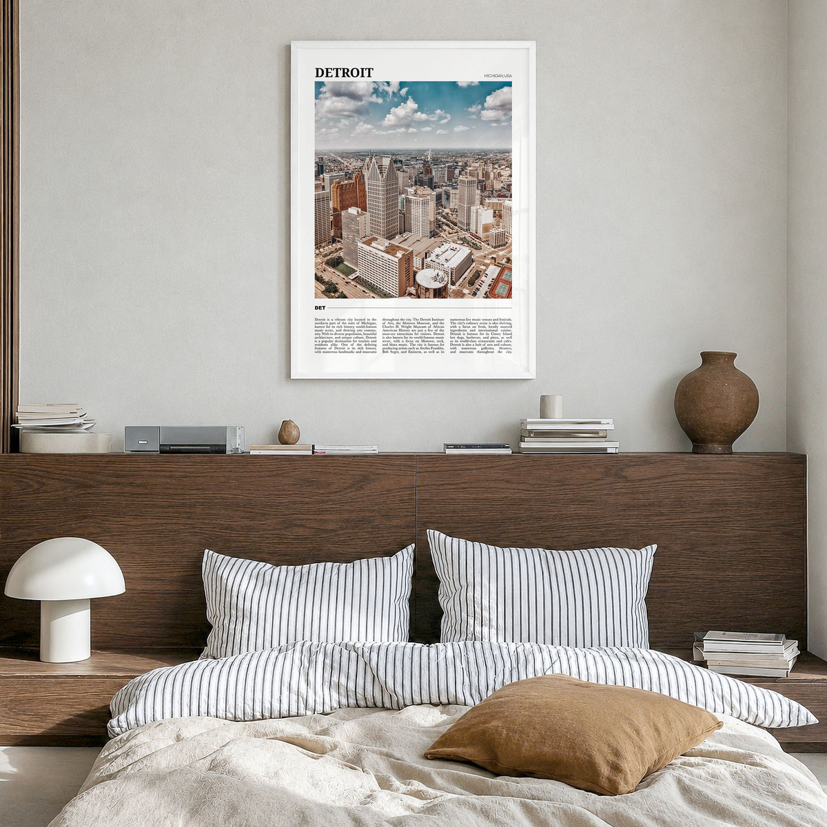 Detroit Travel Poster in a white wood frame, hanging in a bedroom