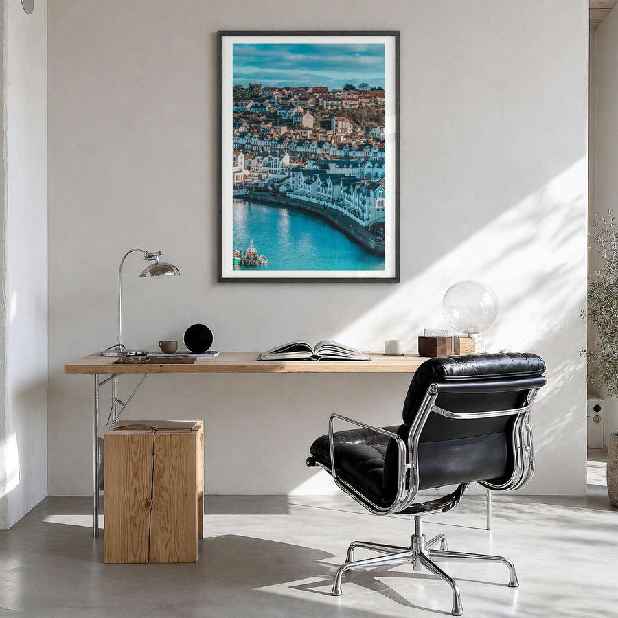 Devon Photo Poster in a black wood frame, hanging in a bright home office, white border