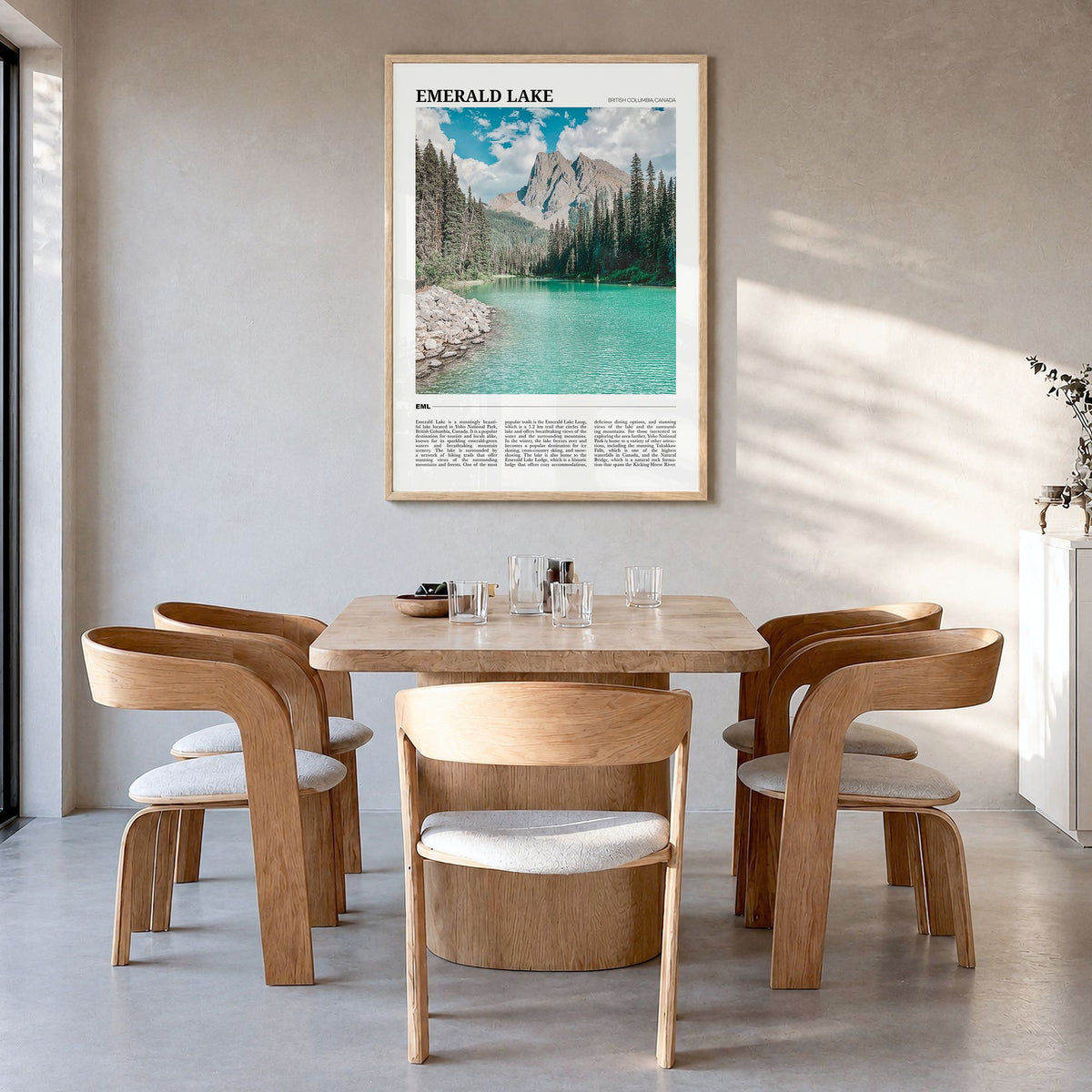 Emerald Lake Travel Poster in a natural wood frame, hanging in a dining room