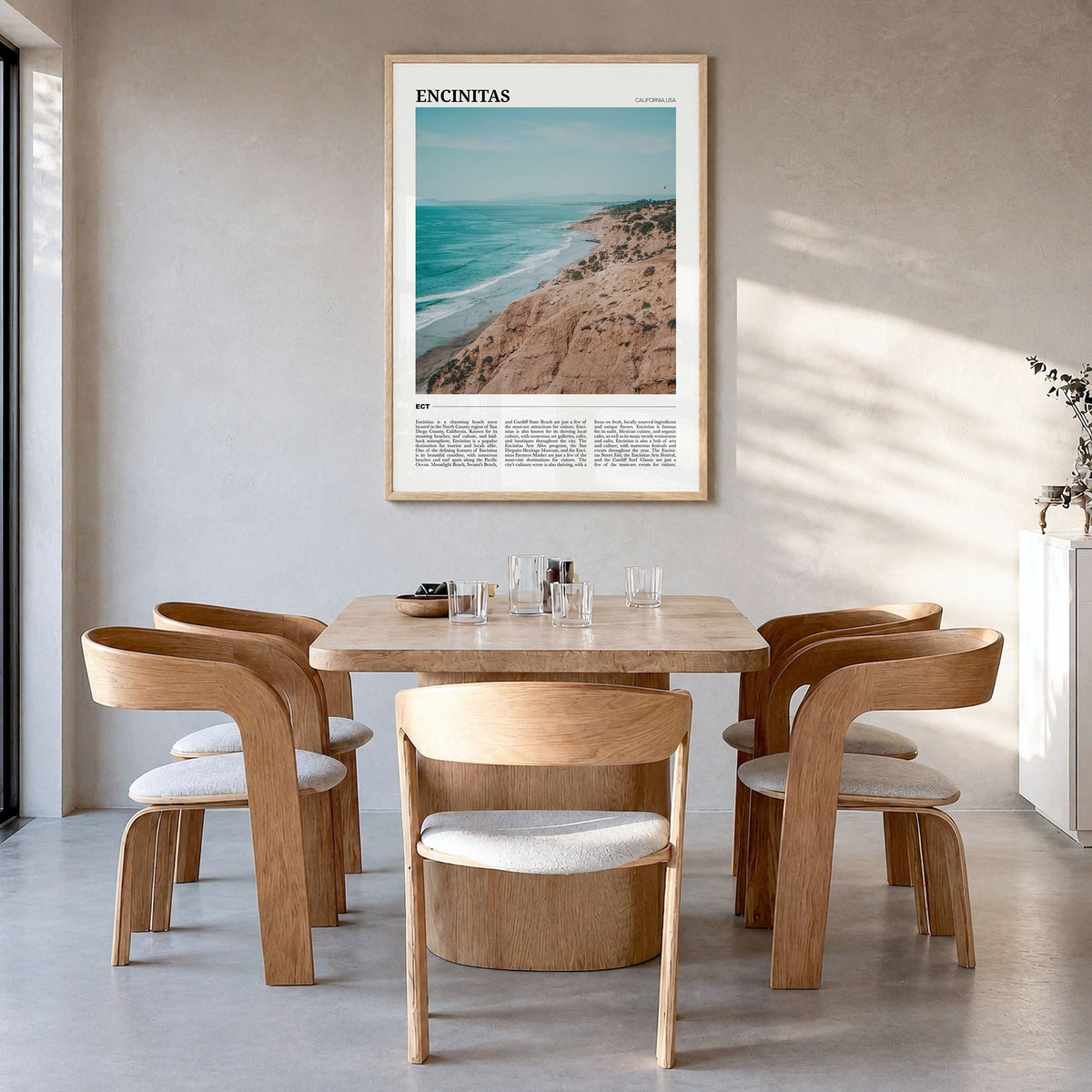Encinitas Travel Poster in a natural wood frame, hanging in a dining room