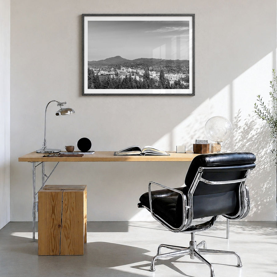 Eugene Photo Poster in a black wood frame, hanging in a bright home office, white border