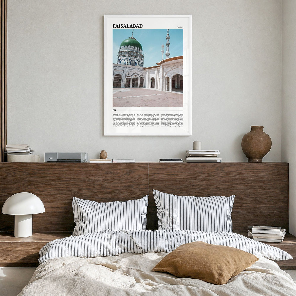 Faisalabad Travel Poster in a white wood frame, hanging in a bedroom